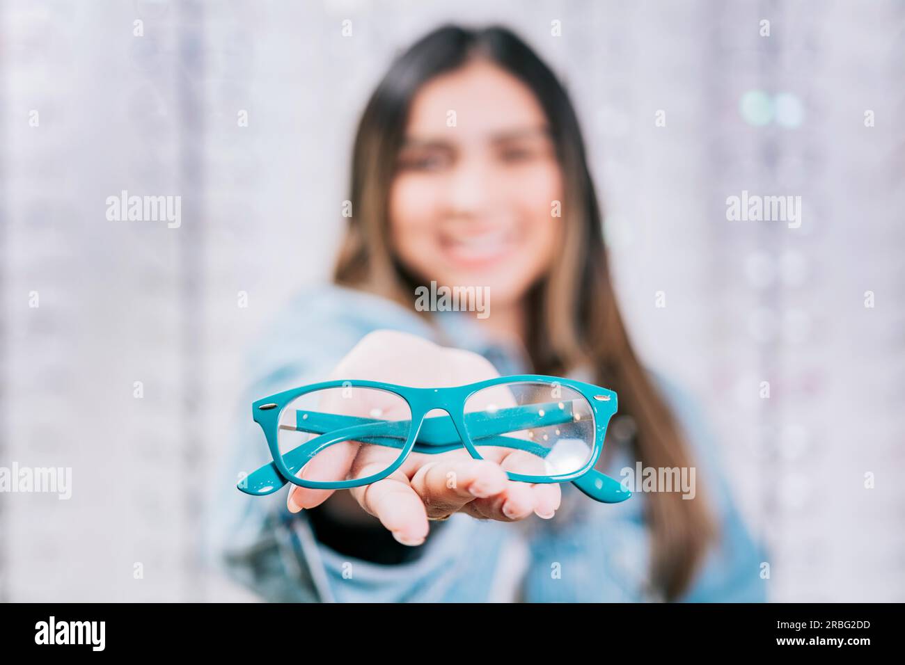 Girl hands showing some glasses in a store. Buyer showing glasses in a store. Happy girl holding glasses in palm hand in a store Stock Photo