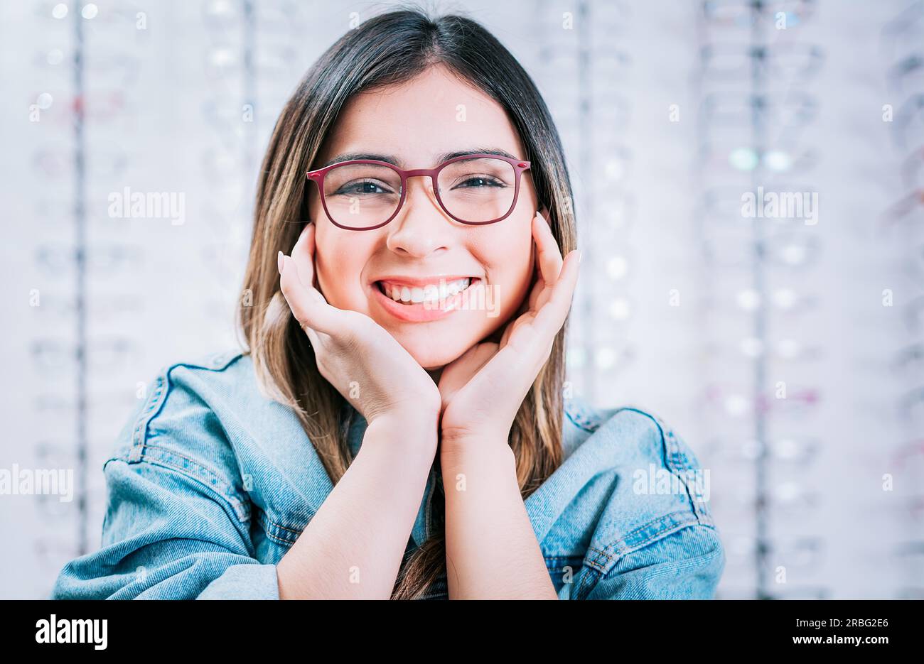 Portrait of beautiful girl modeling glasses in an optical store. Happy