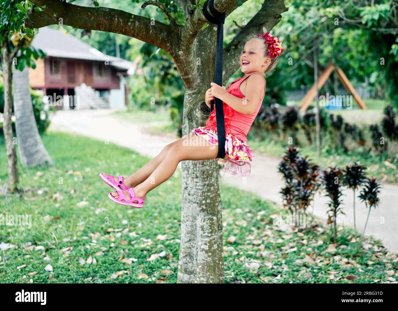 Happy laughing child girl on swing outdoors. Summer activity for children. childhood concept Stock Photo