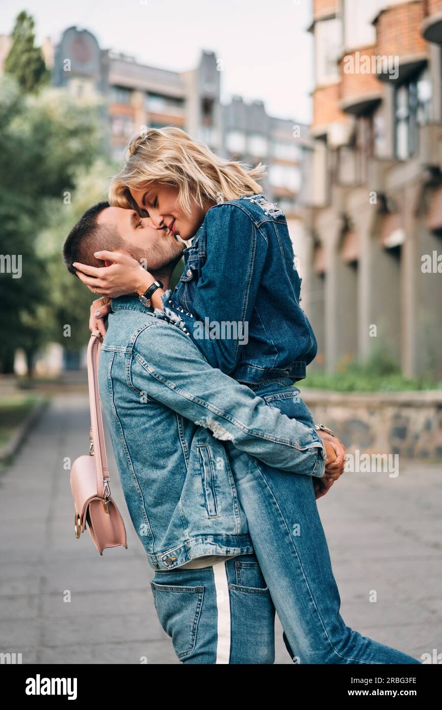 Hugged Couple happy meeting hugging and kissing in the street. Young lovers ...