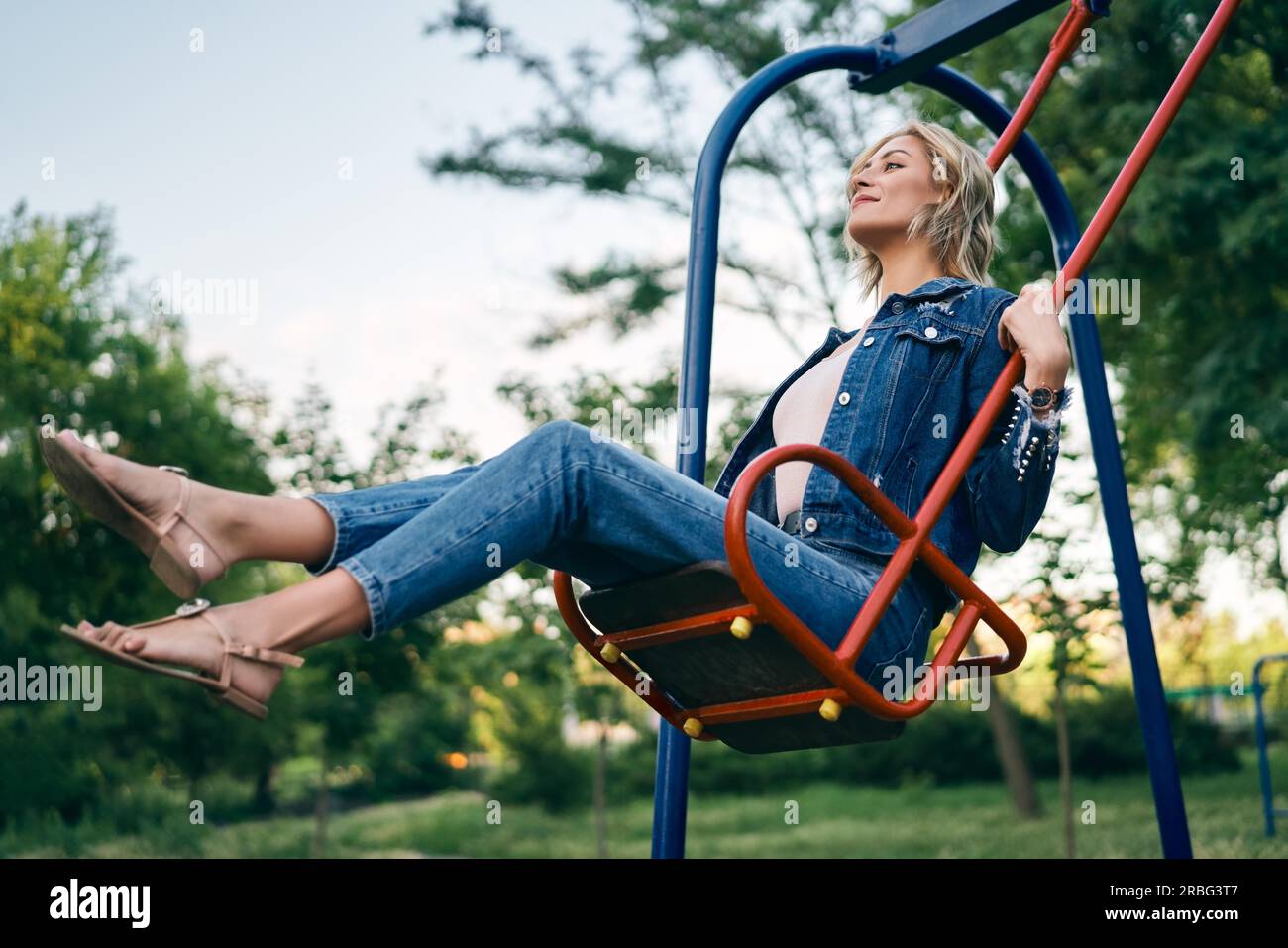 Carefree happy woman on swing outdoors. Happiness and fun concept Stock Photo