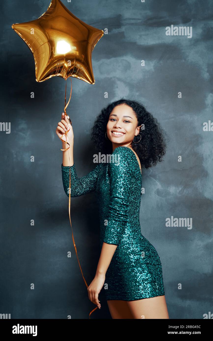 Beautiful young african woman having fun and holding golden balloon. Party time, celebration concept Stock Photo