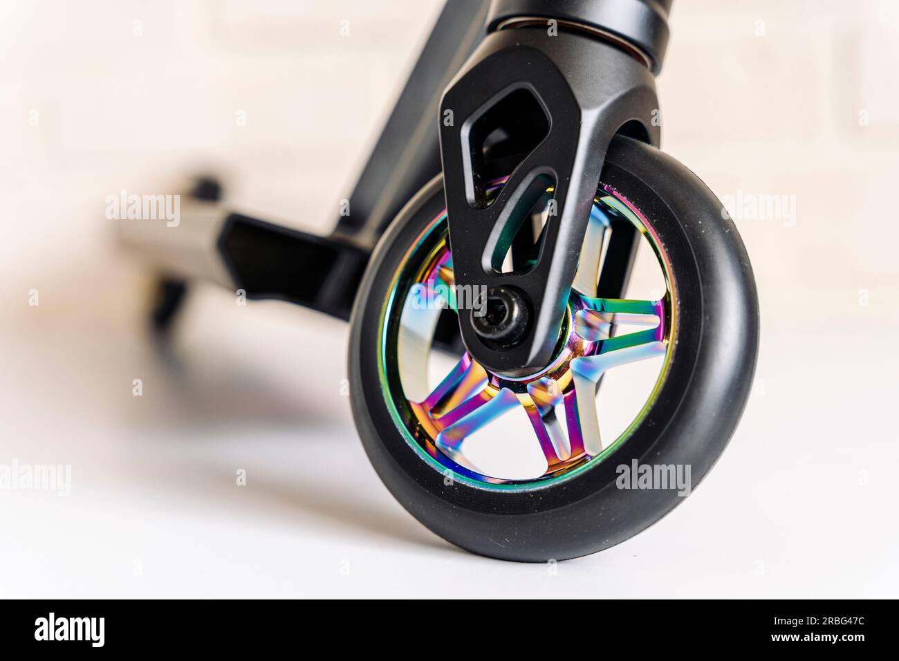 Front view of a stunt scooter with rainbowcolored wheels. equipment