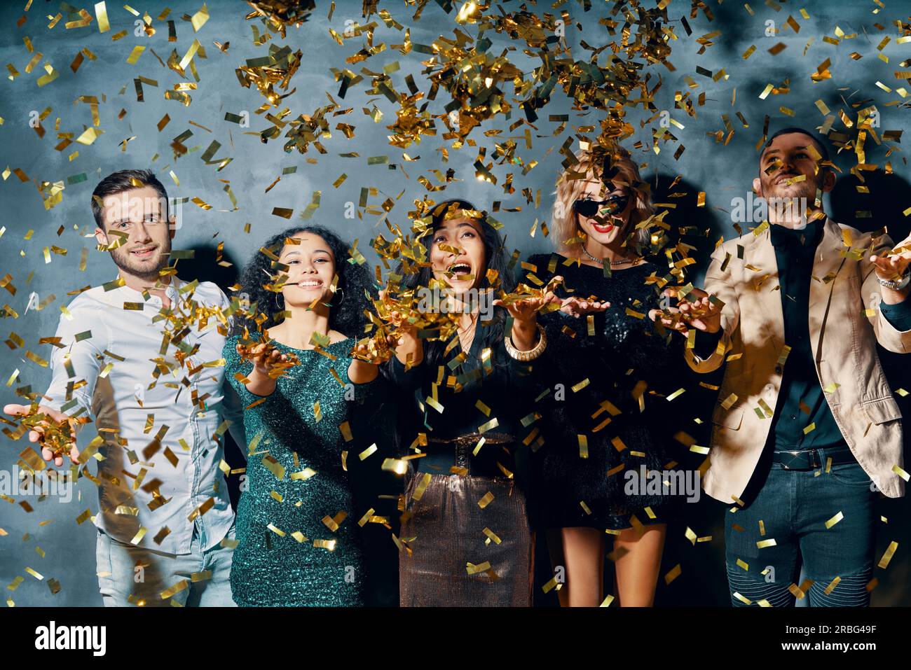 Group of friends enjoying party, dancing and throwing confetti. Celebration concept Stock Photo