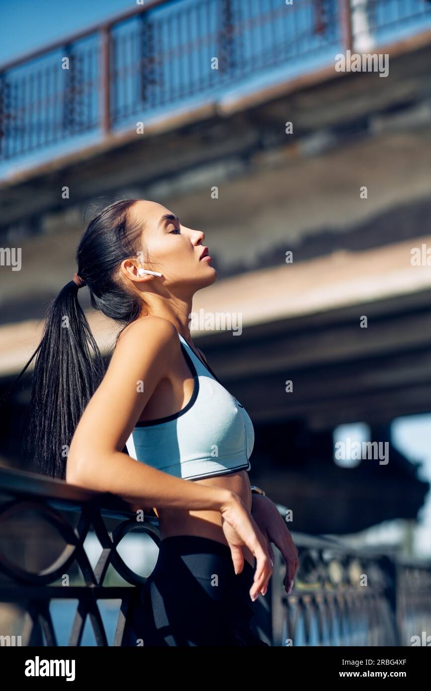 Young fit woman relax and taking a break while running in the city. Sport concept Stock Photo