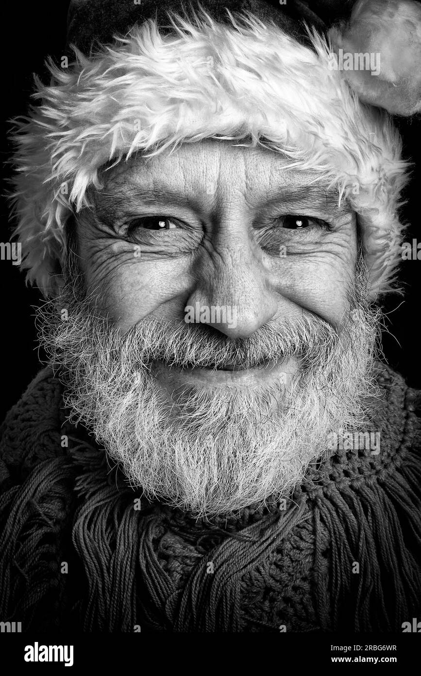 Black and white portrait of an adult man with white beard disguised in Santa Claus for the Christmas Holiday Stock Photo