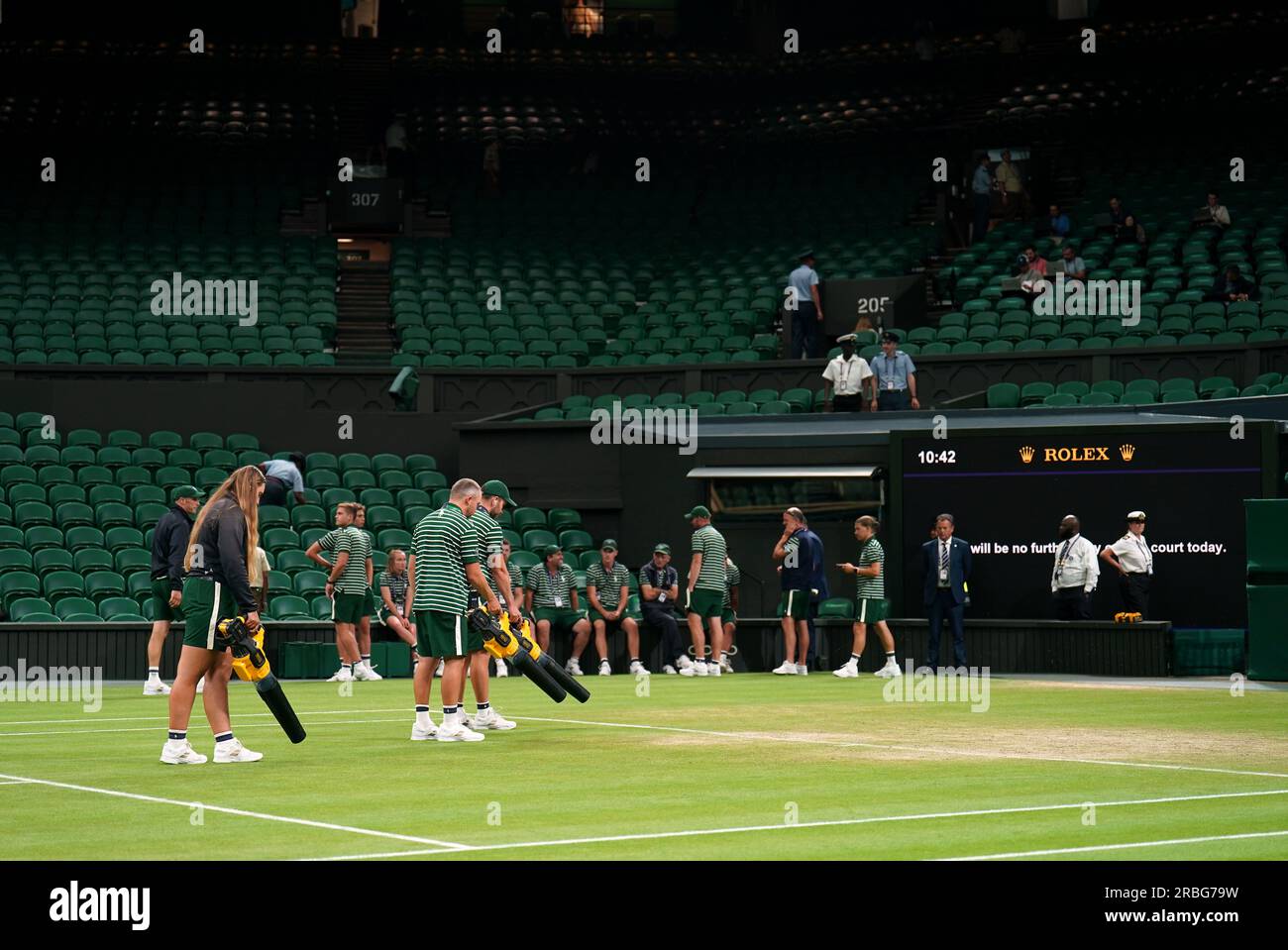 Ground staff on court after play is suspended between Novak Djokovic