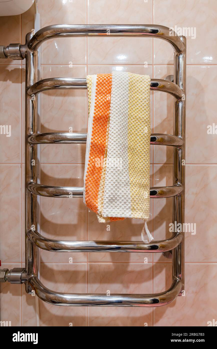 Stainless steel bathroom heated towel rail radiator, with a towel Stock Photo Alamy