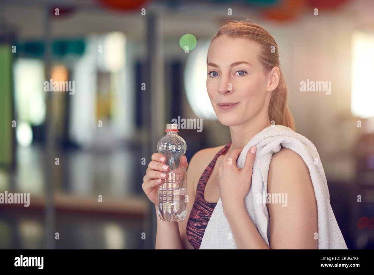 https://c8.alamy.com/comp/2RBG7KH/young-woman-athlete-drinking-bottled-water-for-hydration-after-working-out-in-a-gym-in-a-health-and-fitness-concept-2RBG7KH.jpg