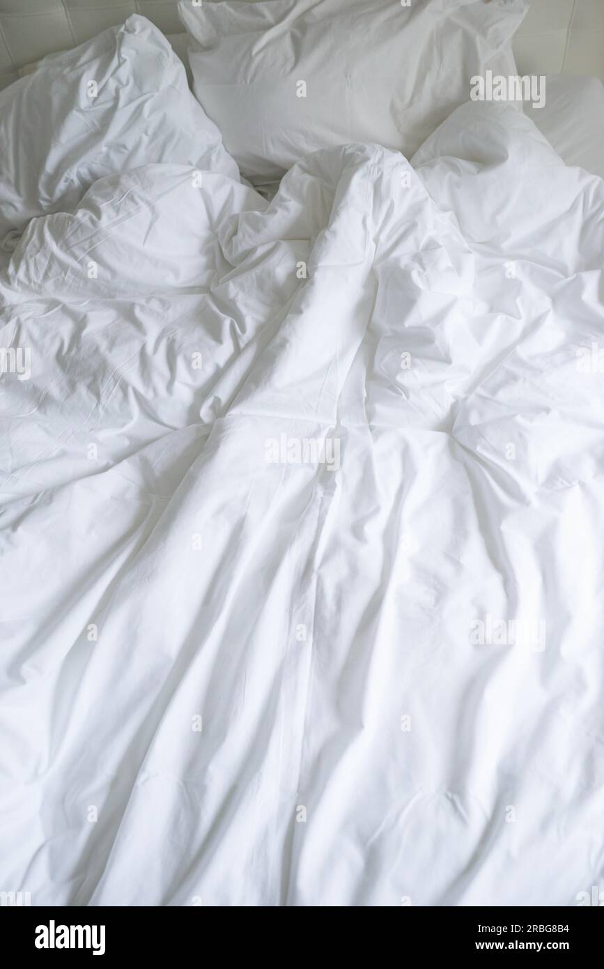 unmade-bed-with-plain-white-bed-linen-in-a-close-up-view-of-a-rumpled