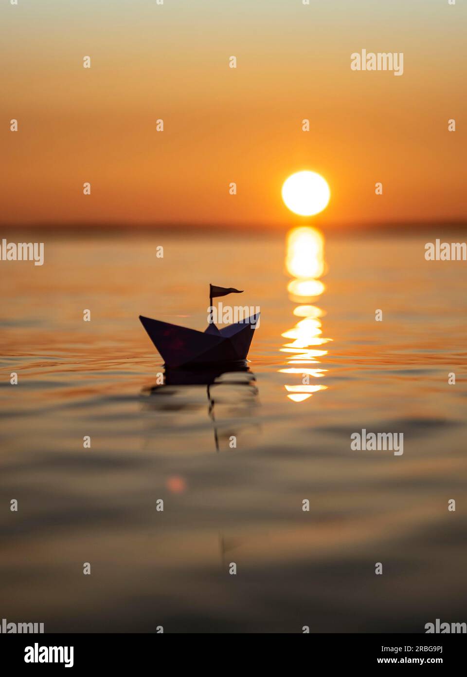 Paper ship in the sunset Stock Photo