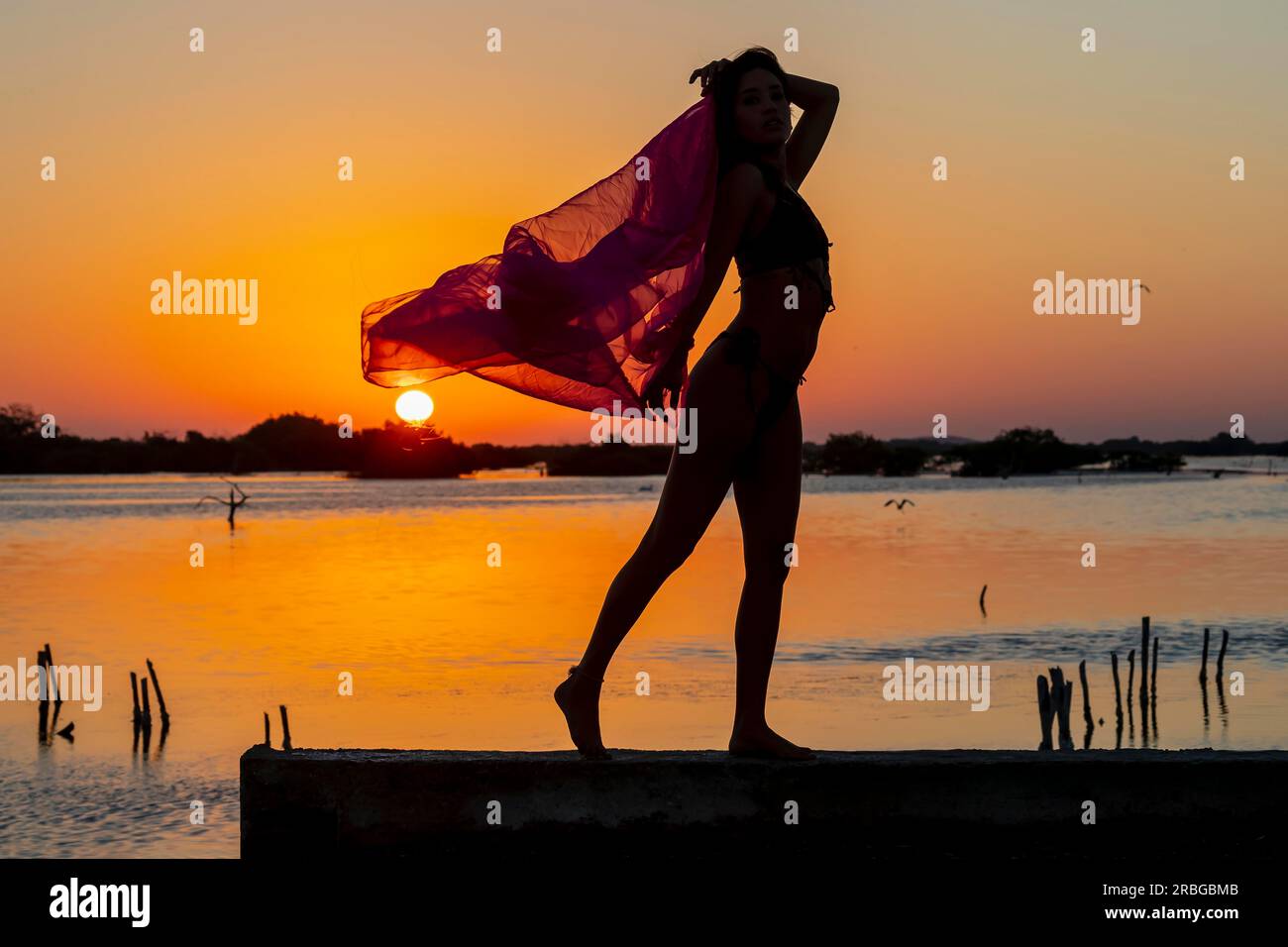 A beautiful hispanic brunette model enjoying the morning sun at sunrise Stock Photo