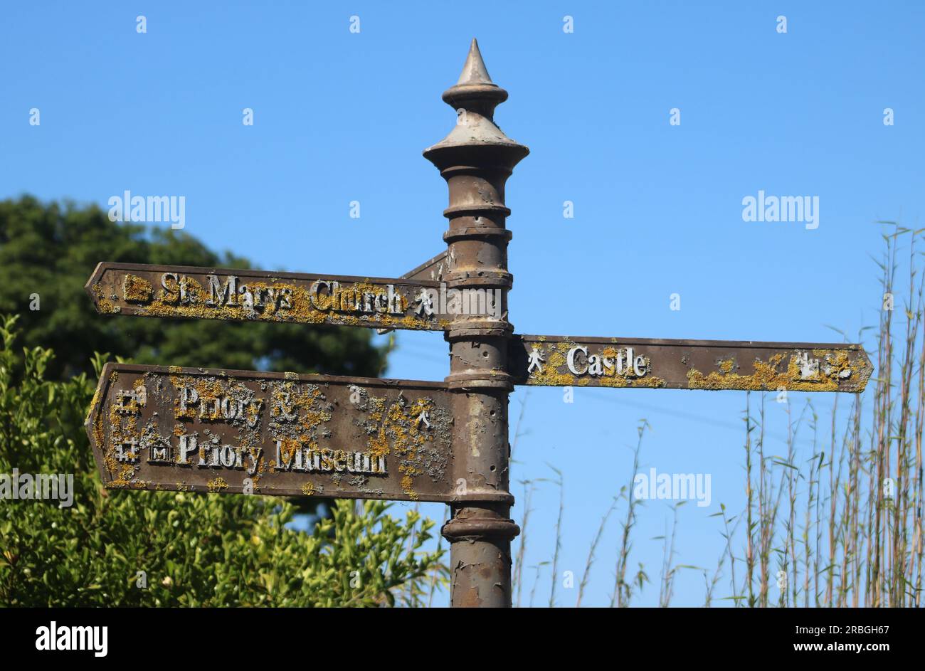 Old weathered fingerpost type sign post, Lindisfarne giving direction of local places of interest, Priory Museum, Priory, St Marys Church and Castle. Stock Photo