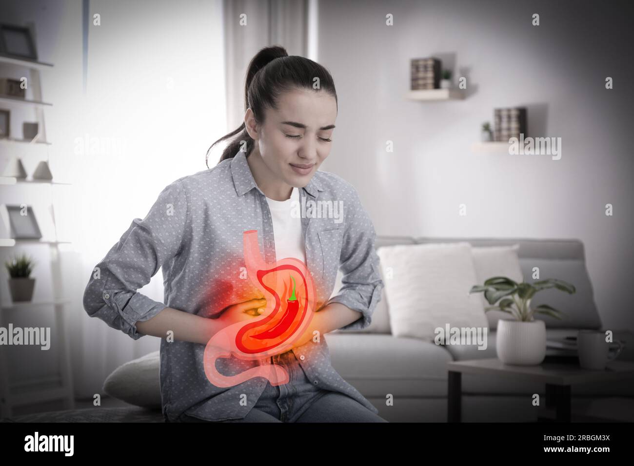 Woman suffering from heartburn at home. Stomach with hot chili pepper