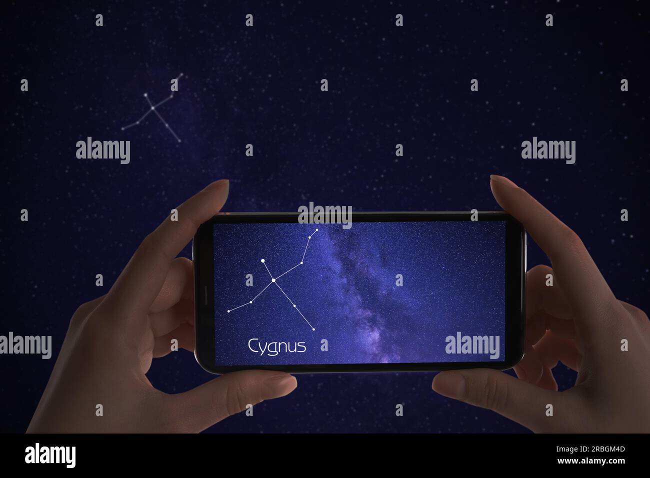 Woman using stargazing app on her phone at night, closeup. Identified stick figure pattern of Swan (Cygnus) constellation on device screen Stock Photo