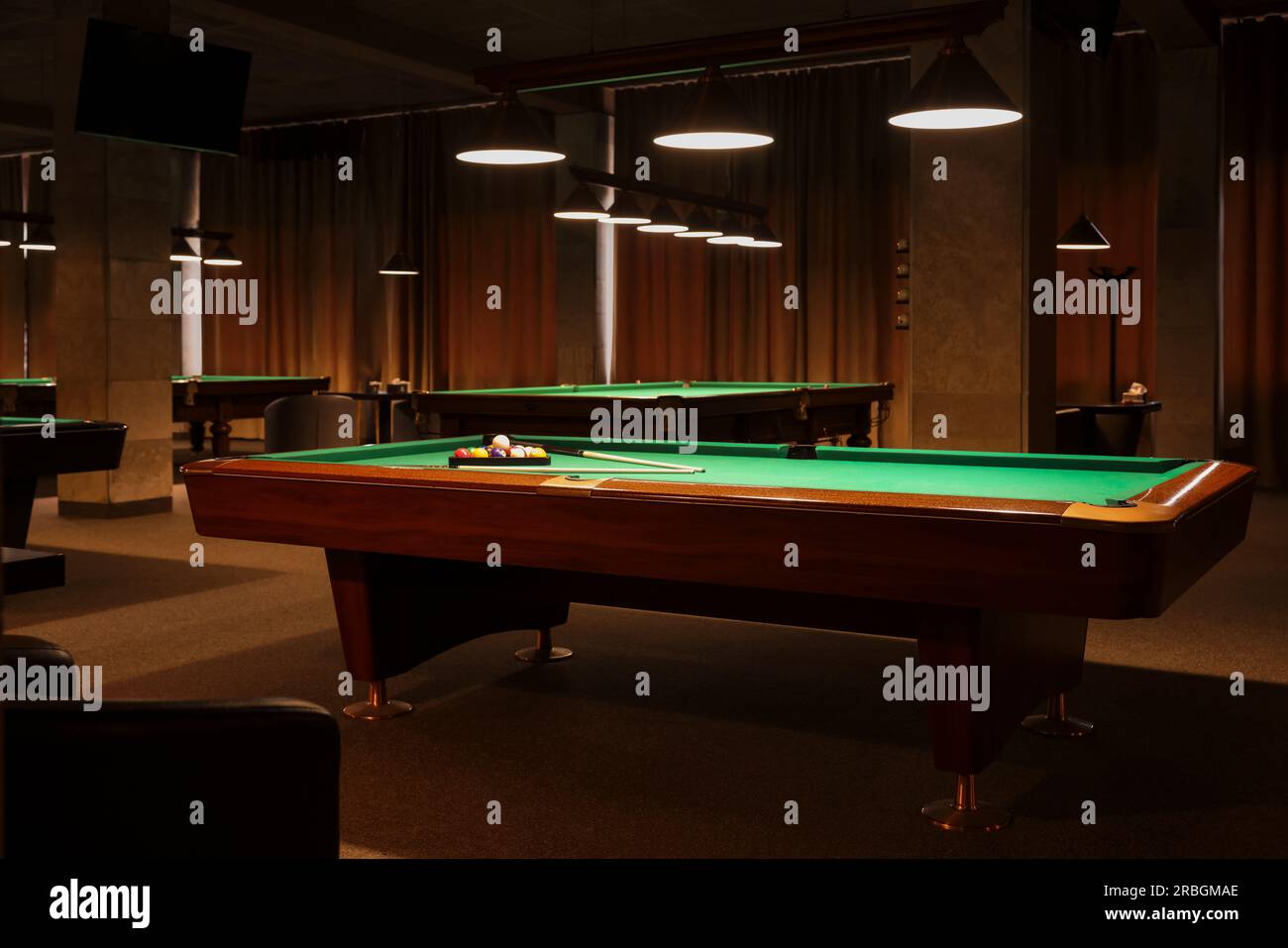 Billiard tables with balls and cues in club Stock Photo
