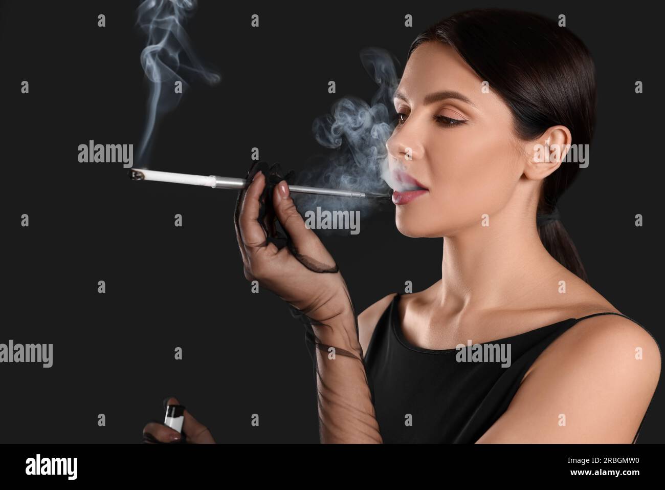 smoking long cigarettes Woman using long cigarette holder for smoking on black background Stock  Photo