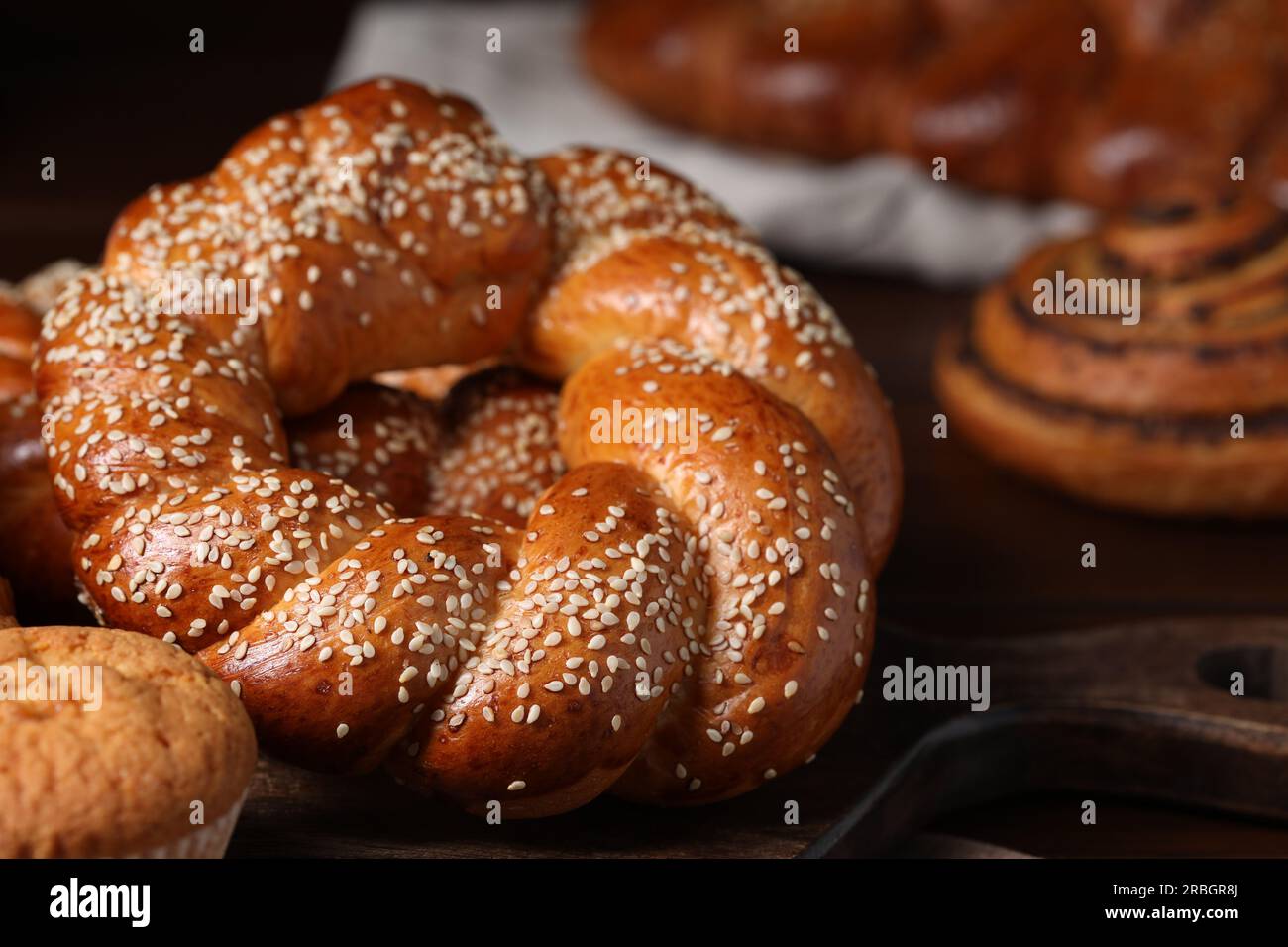 Freshly baked round braided bread and other pastries on table, closeup Stock Photo