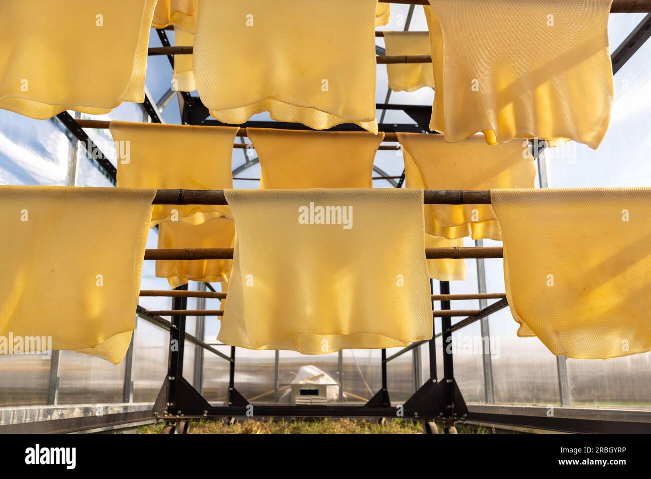 Rubber sheets hanging on rail for dry process air dried sheet (ADS