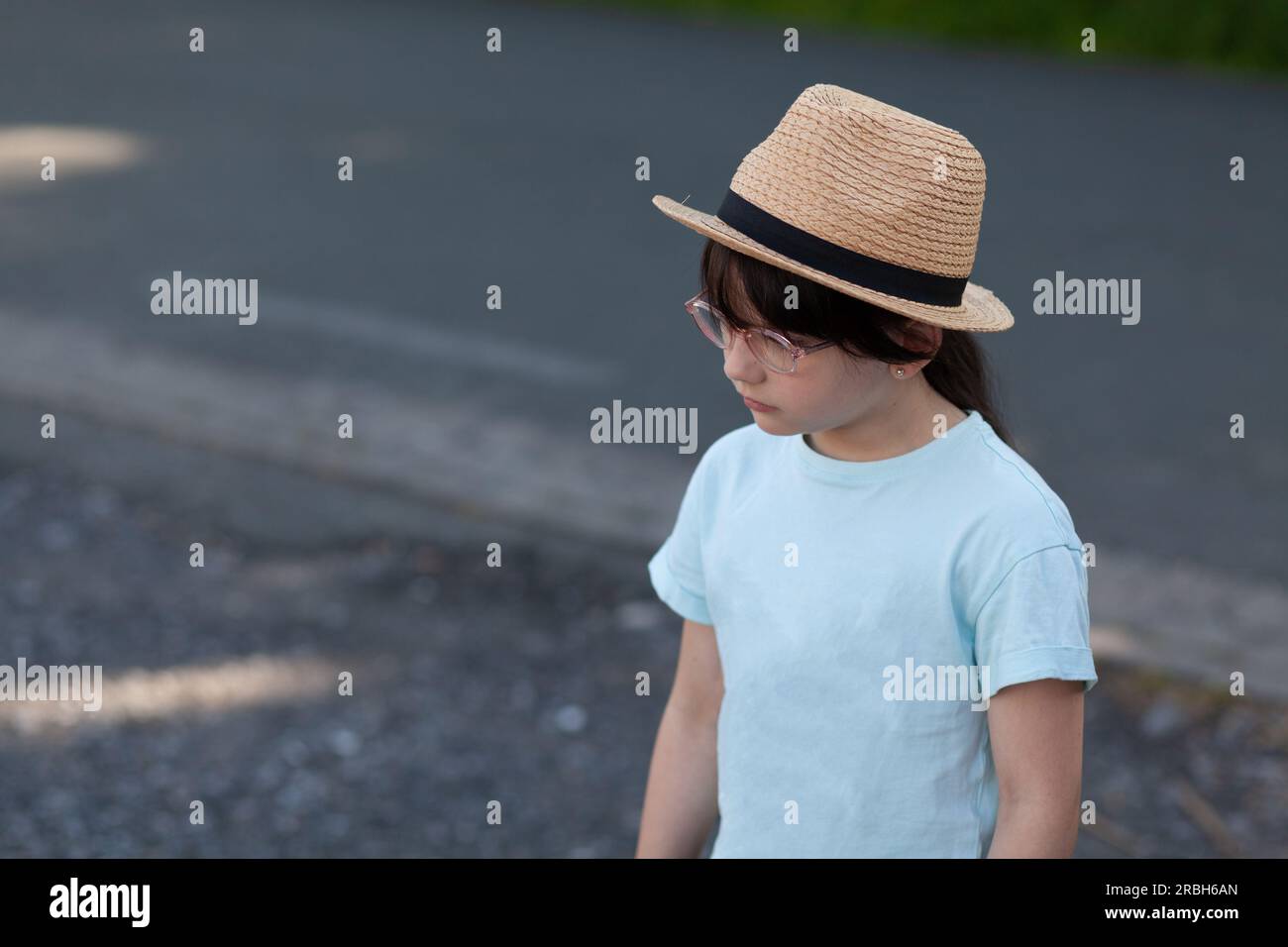 Portrait of little girl wearing straw hat and blue t-shirt Stock Photo