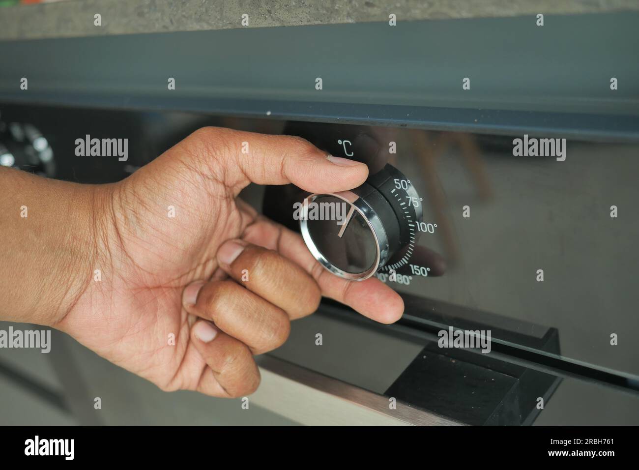 woman hand setting temperature control on oven Stock Photo - Alamy