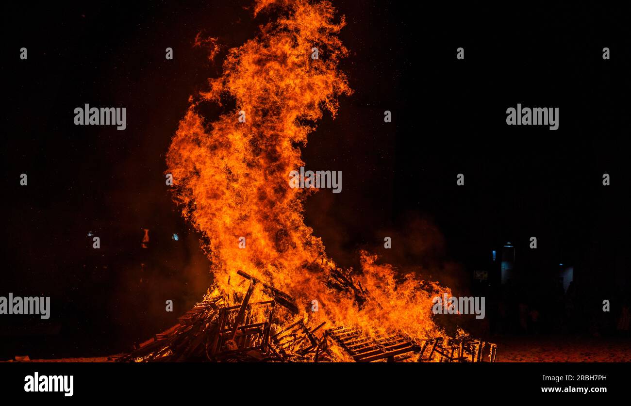 bonfire on the beach at night with high flames on a tribal celebration ...