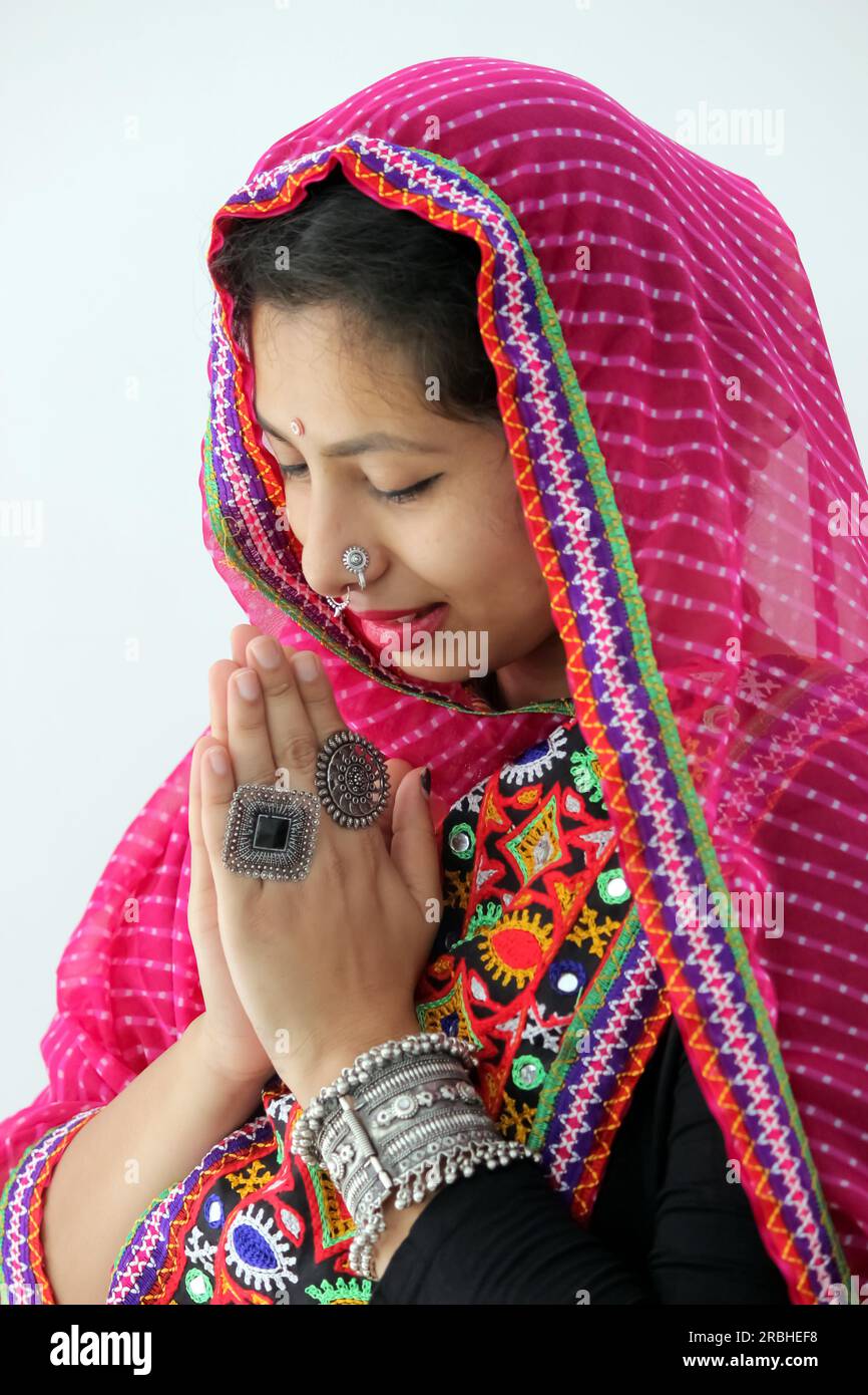 Indian woman closeup portrait with traditional attire and greeting gesture. Praying to the goddess on occasion of Navratri. Wearing pink dupatta Stock Photo