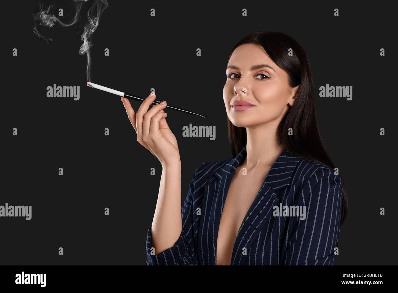 cigarette smoking holder Woman using long cigarette holder for smoking on black background Stock  Photo