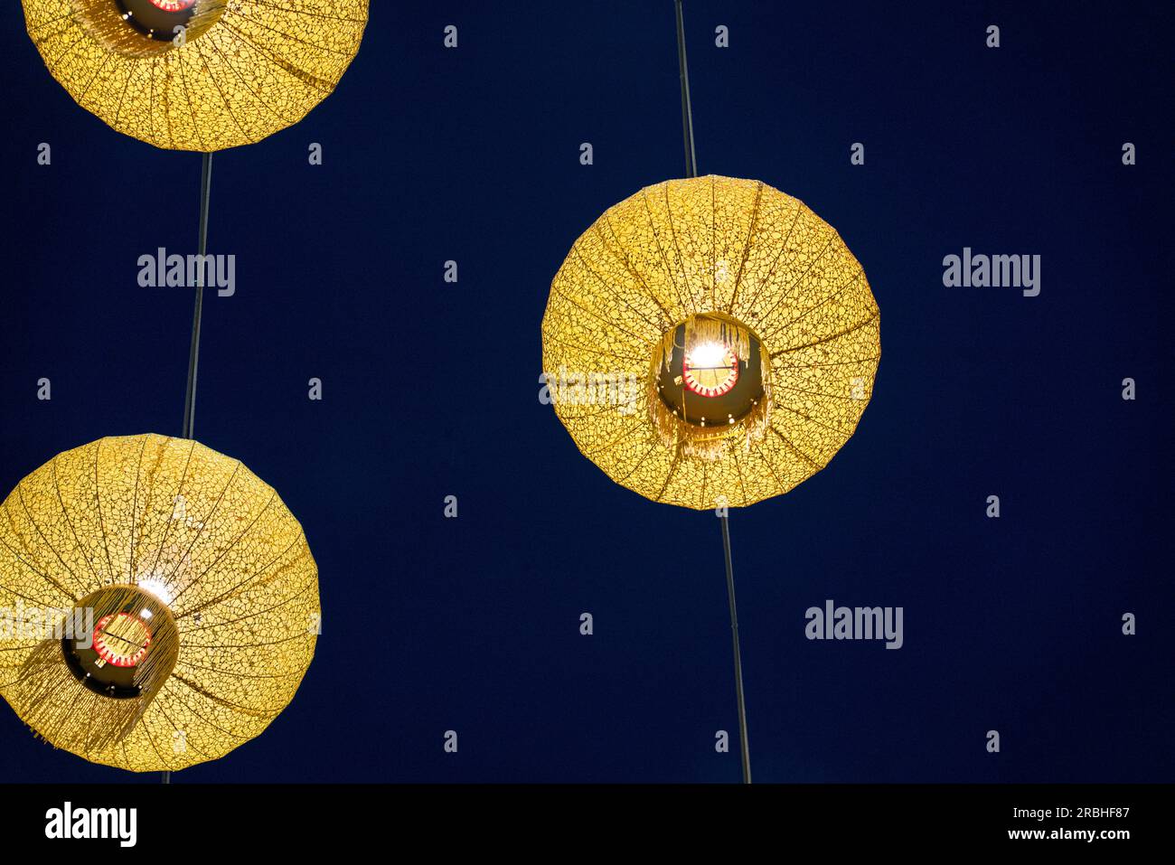 Yellow Chinese lanterns hanging up with sky background. Copy space
