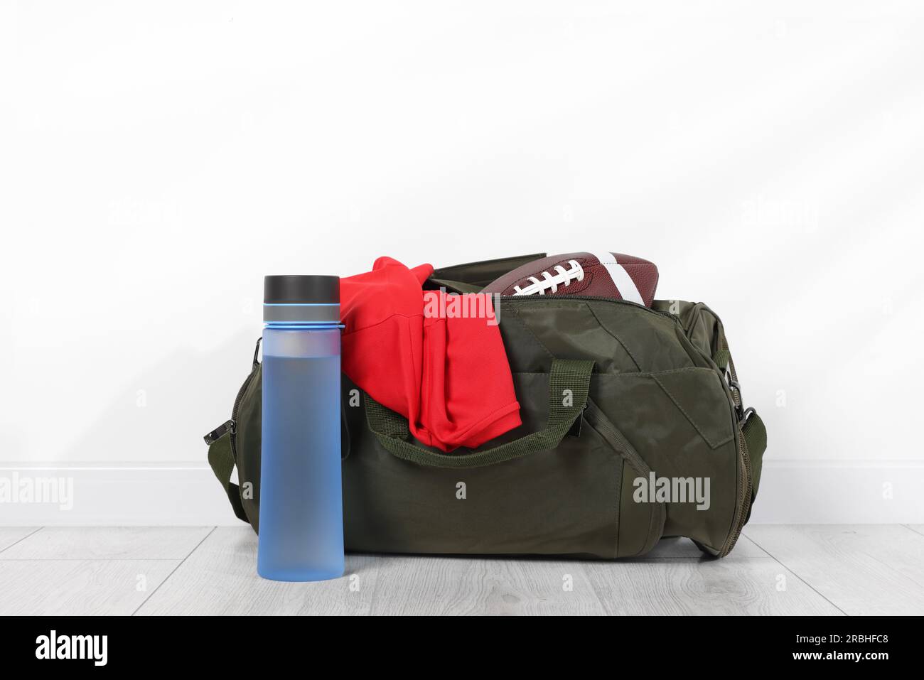 Gym bag and sports equipment on floor near white wall Stock Photo - Alamy