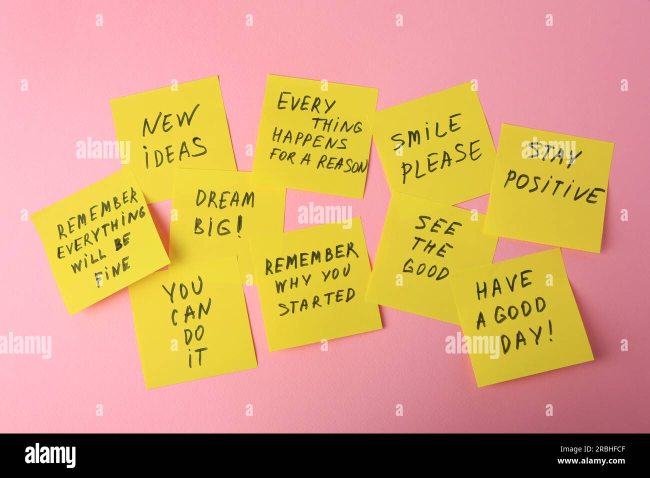 Paper notes with life-affirming phrases on pink background Stock Photo