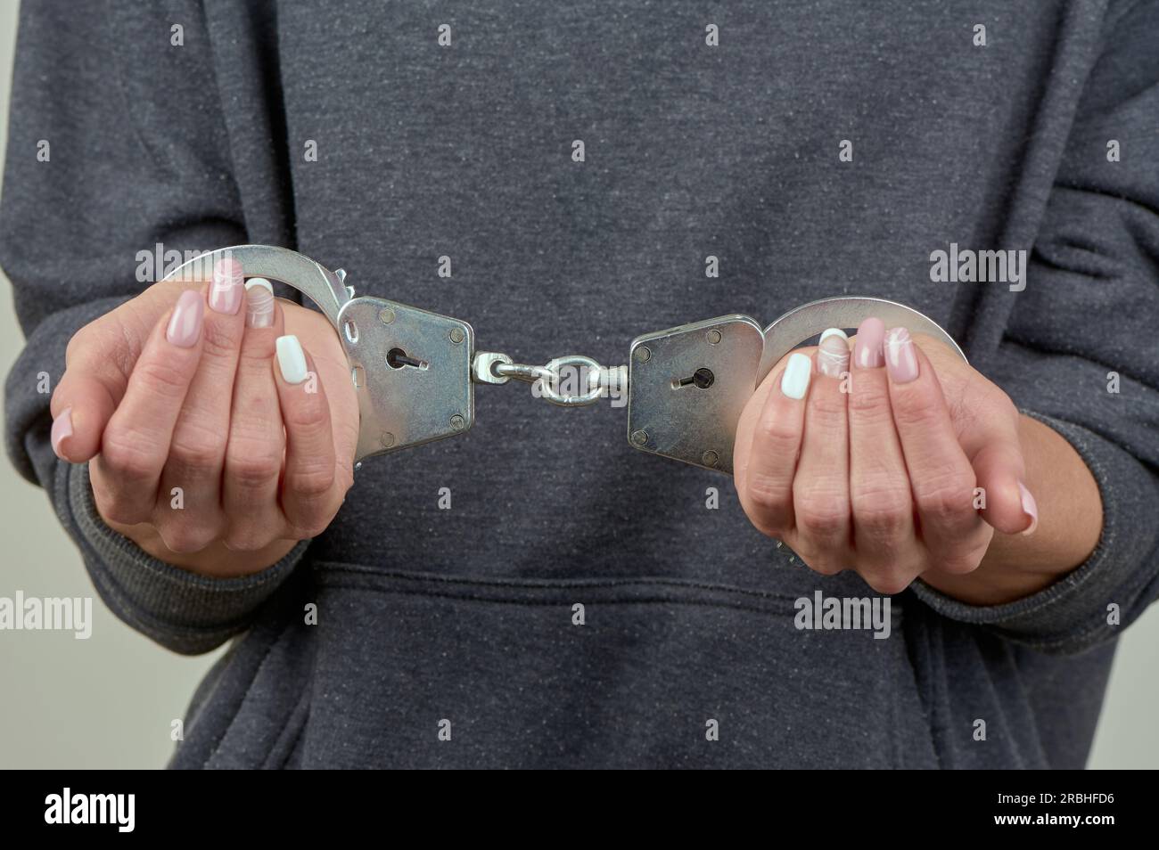women's hands are handcuffed in close-up Stock Photo