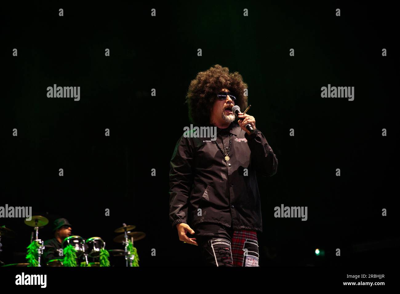 B-Real of Cypress Hill performs on stage sporting sunglasses, a large ...