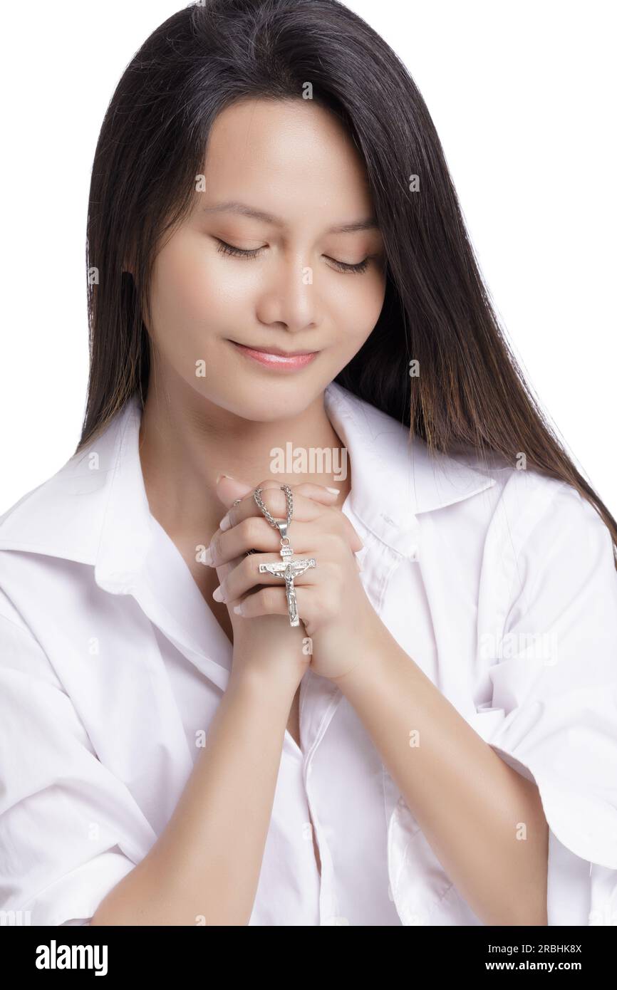 Young Catholic Asian American praying on a white background with copy space Stock Photo
