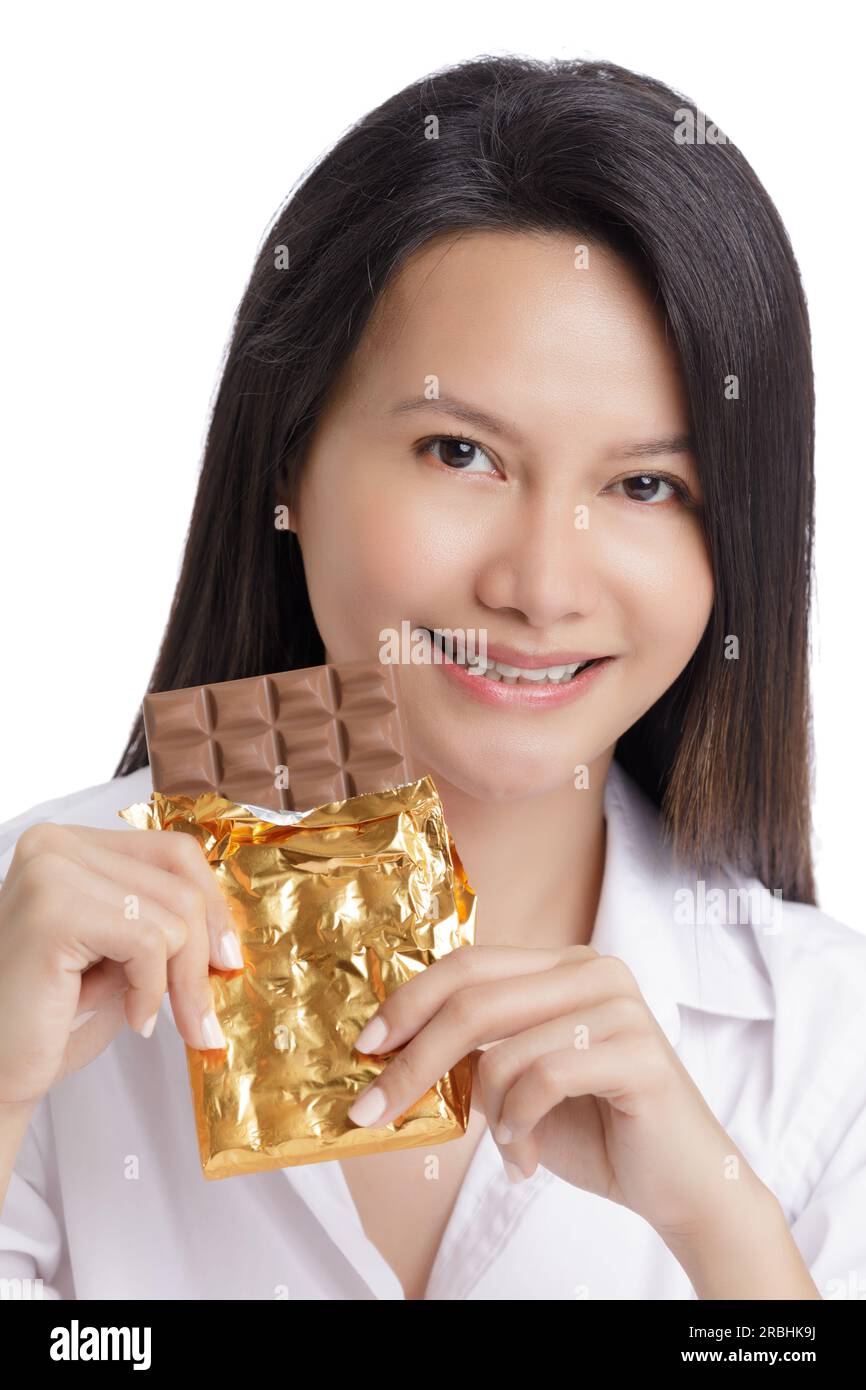 Asian American woman enjoying a Milk Chololate candy bar isolated on a white background with copy space Stock Photo