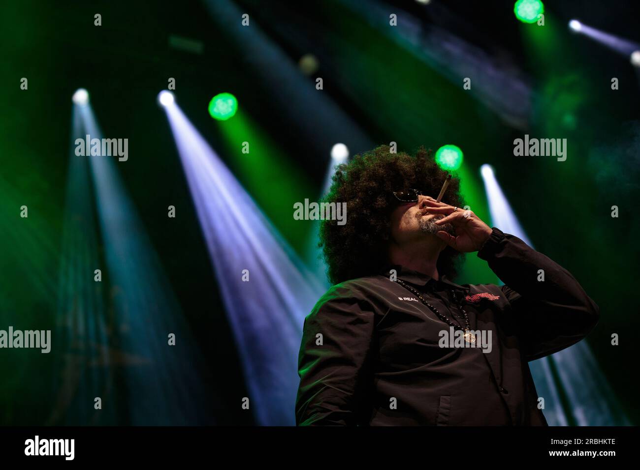 B-Real of Cypress Hill performs on stage sporting sunglasses, a large ...