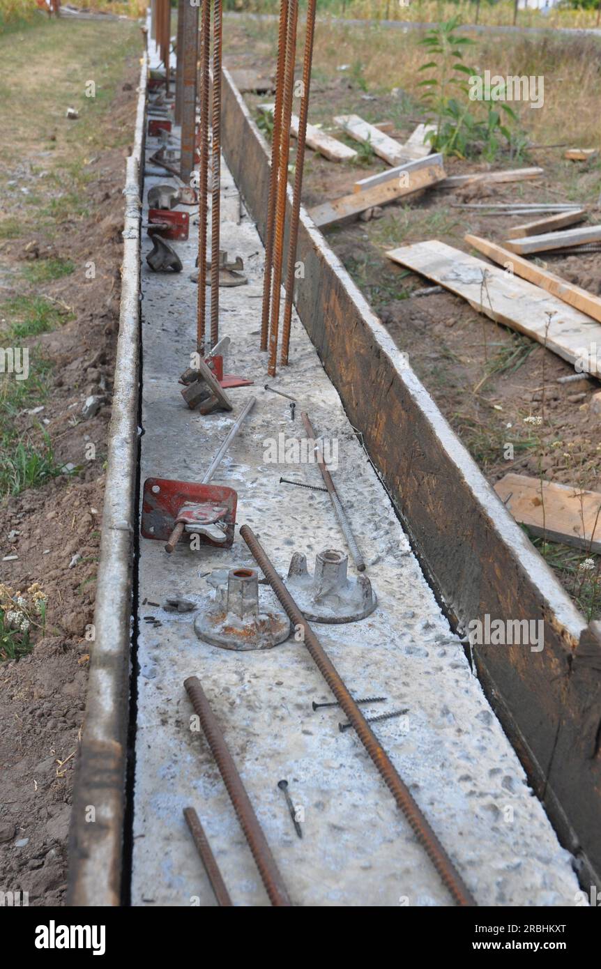 The concrete footer installed along the length of this fence. Pour