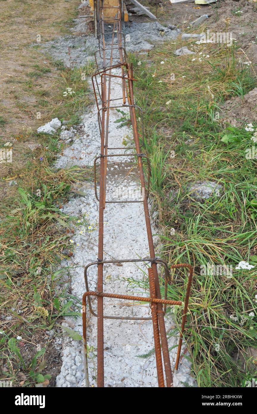 Building concrete foundation for fence with reinforcing bars. Steel
