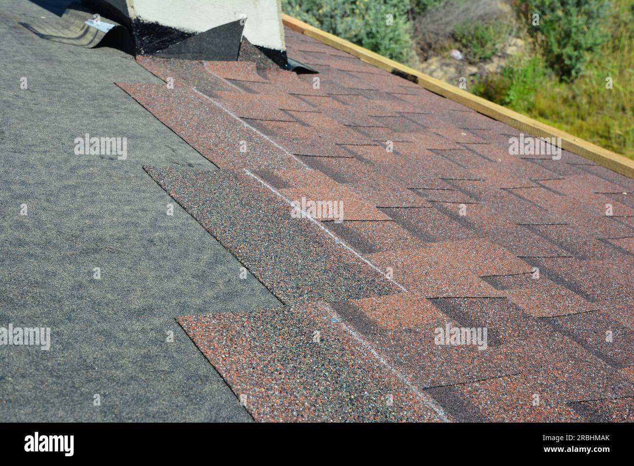 Installing asphalt roof shingles on the underlayment of the house