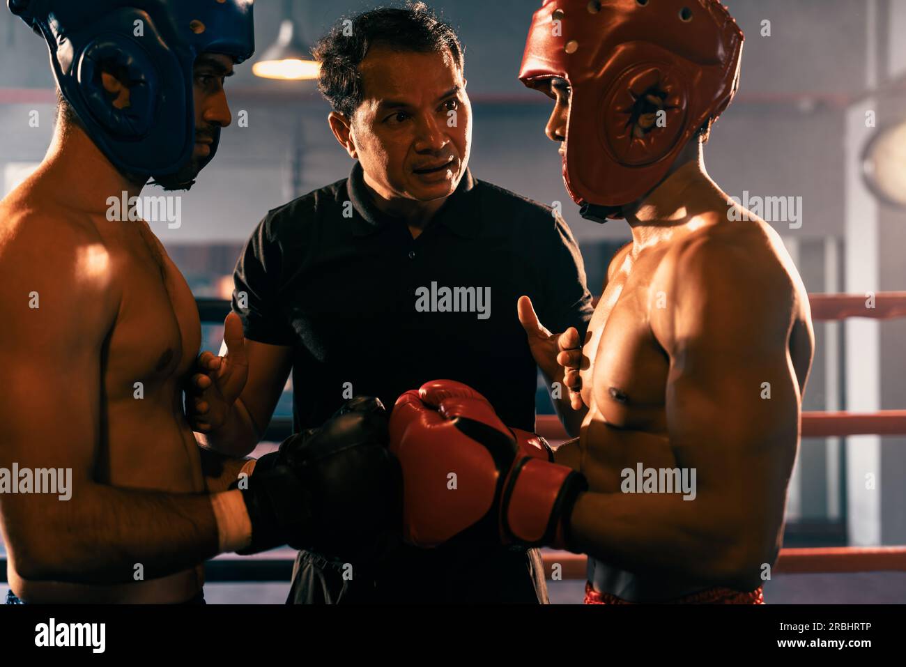 Boxer fighter with safety helmet or head guard face off with each other  while referee explain rules of engage to competitor before start boxing  match Stock Photo - Alamy