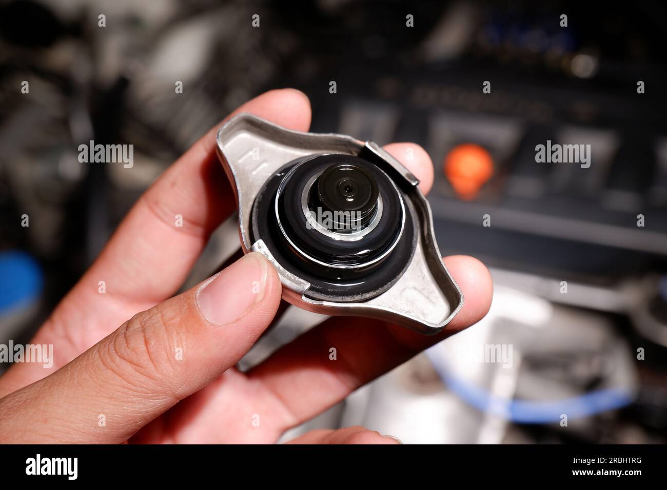 Mechanic hand holding car radiator cap, inside of radiator cap