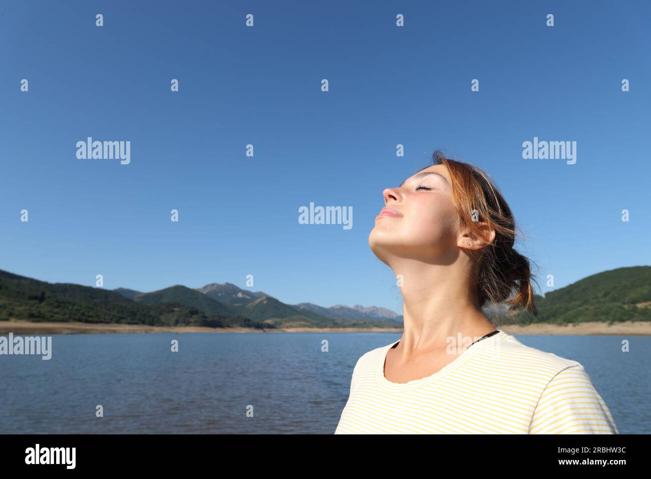Relaxed woman breathing fresh air in a lake a sunny day Stock Photo - Alamy