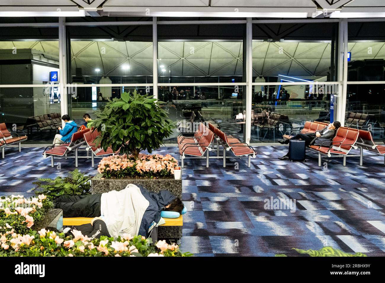 Long layovers and tired passengers sleeping on seats at Hong Kong