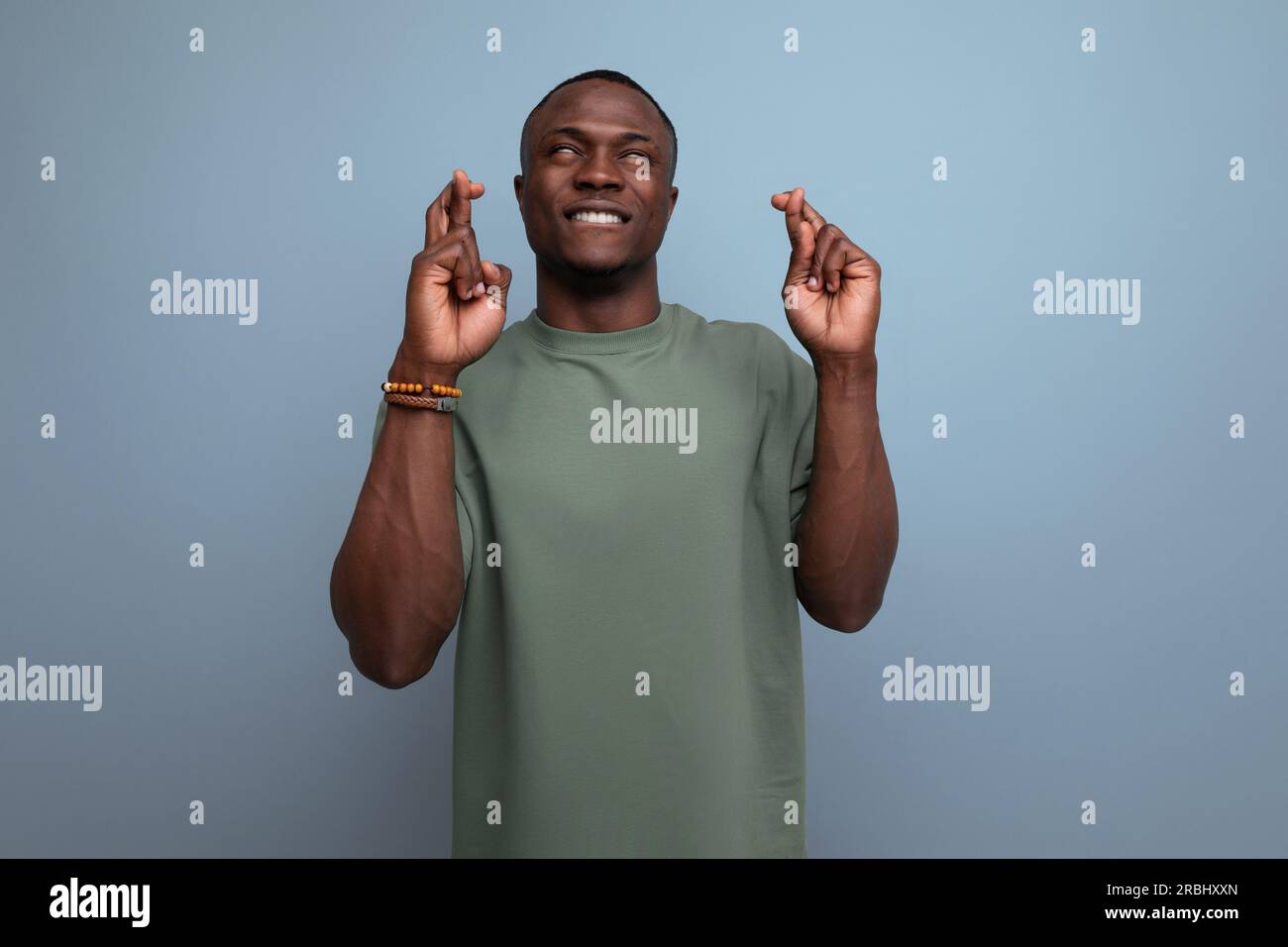 young attractive african man dressed in t-shirt hopes for good luck on ...
