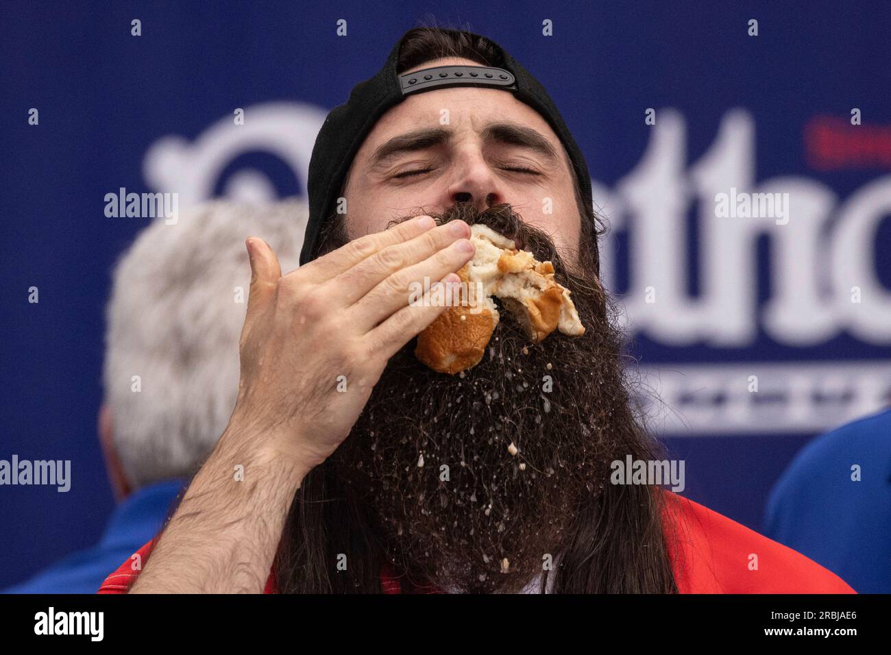 Competitive eater Adam Moran eats hot dogs during the 2023 Nathan's
