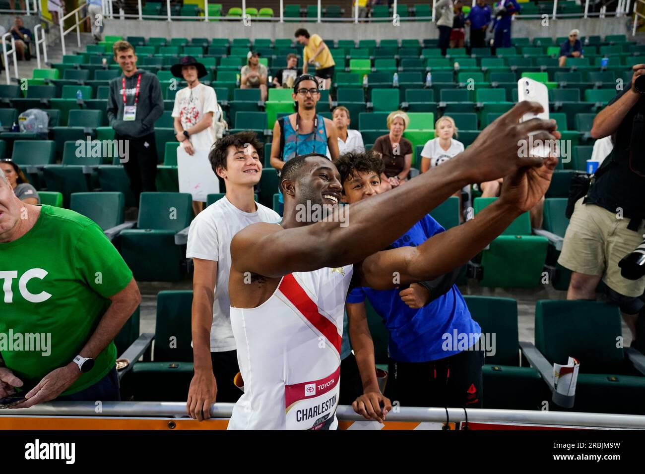 Cravont Charleston, who won the men's 100 meters, takes photos with