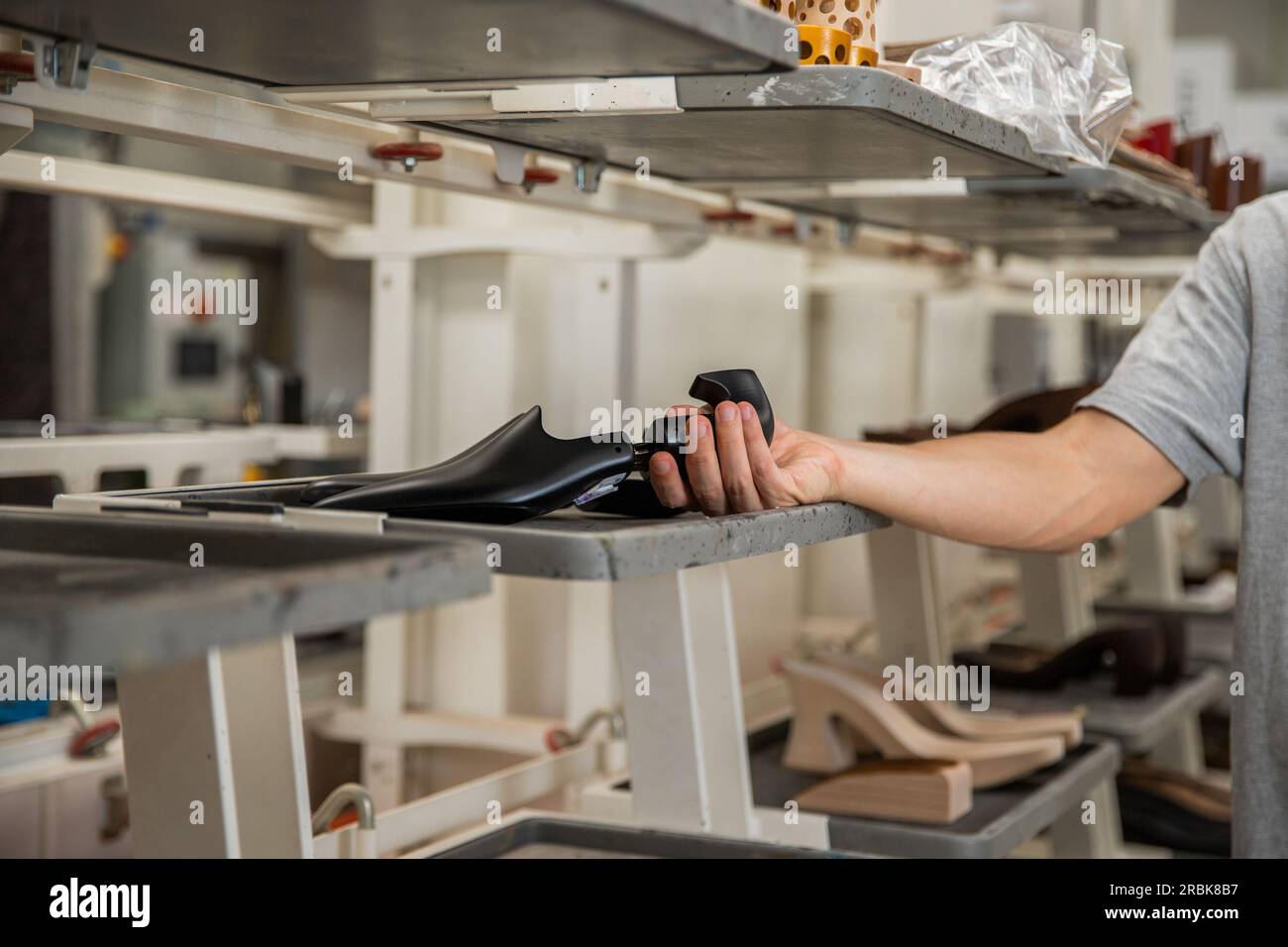 A shoe maker holding a shoe last inside the manufacturing factory Stock Photo