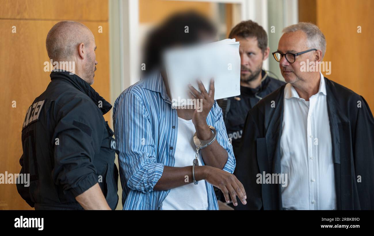 Aschaffenburg, Germany. 10th July, 2023. The defendant talking to his defense attorney Christoph Jahrsdörfer (r). The prosecution accuses the German with Kenyan roots of attempted murder, among other things. The man is alleged to have severely abused the boy last October. He is also charged with abuse of a ward because he is said to have attacked two of his three children before that. Credit: Heiko Becker/dpa/Alamy Live News Stock Photo