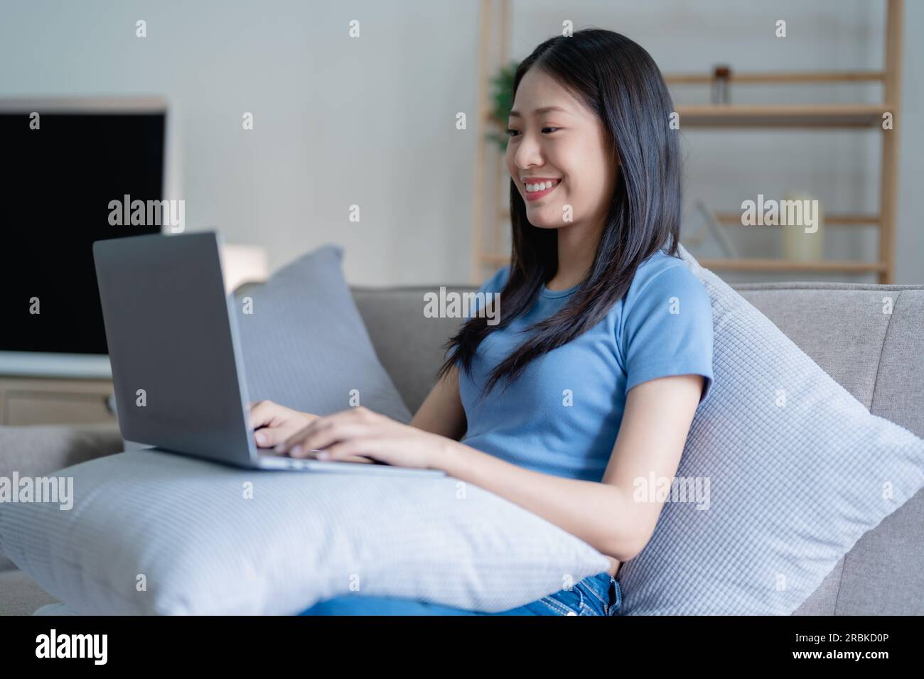 Asian Beautiful young woman relaxing on a couch at home with using ...