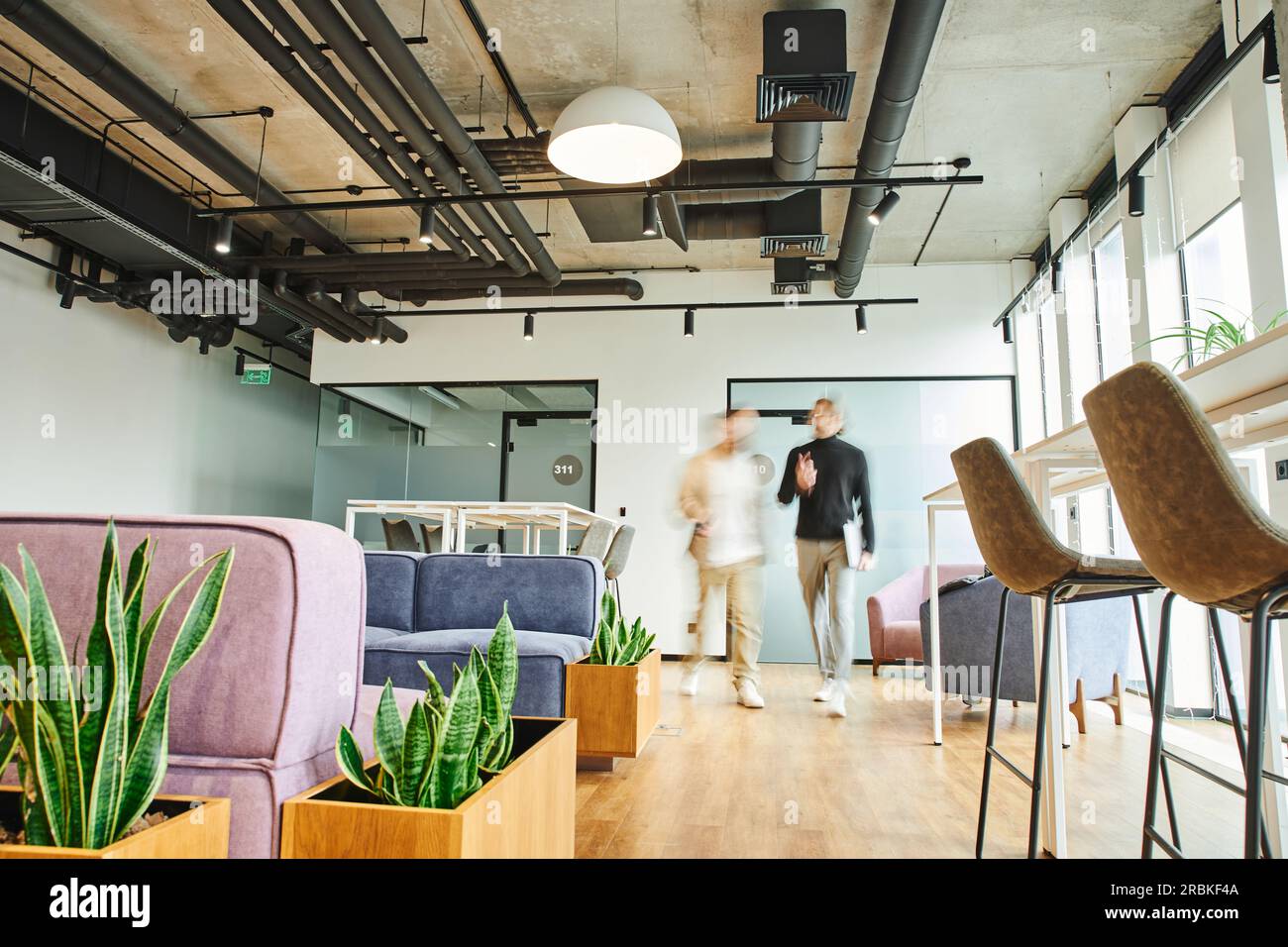 motion blur of business partners walking in lounge of contemporary
